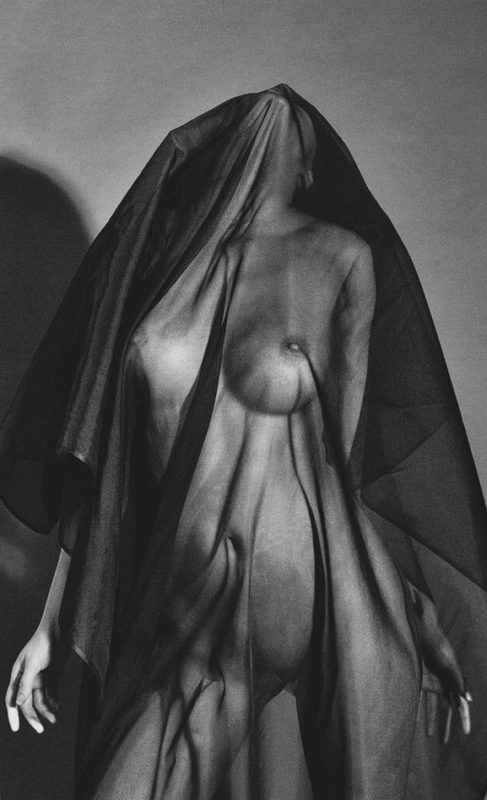 Femme nue debout, recouverte d'un fin tissu noir translucide
