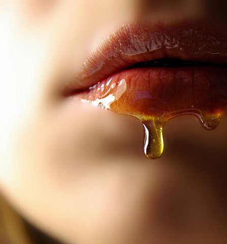 une goutte de miel perle sur une bouche